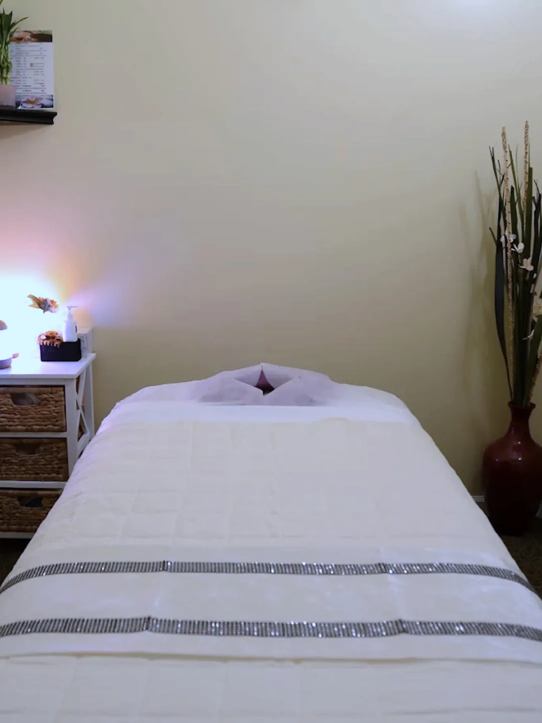 A single treatment room at LJY Reflexology in Hermitage, TN, with the table made up and warm side lighting
